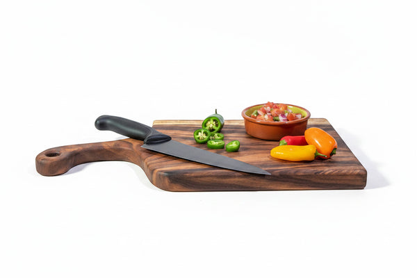 Tuckahoe Hardwoods large live edge East Indian Walnut handled cutting board with knife, jalapeños, mini peppers, and salsa.